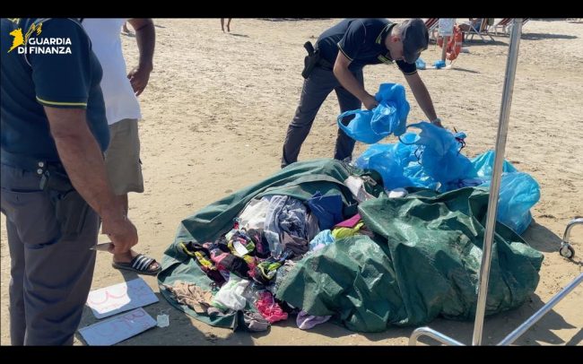 Guardia di Finanza su lungomare con articoli sequestrati: borse, occhiali, bigiotteria e accessori abbigliamento confiscati, immagine di approfondimento
