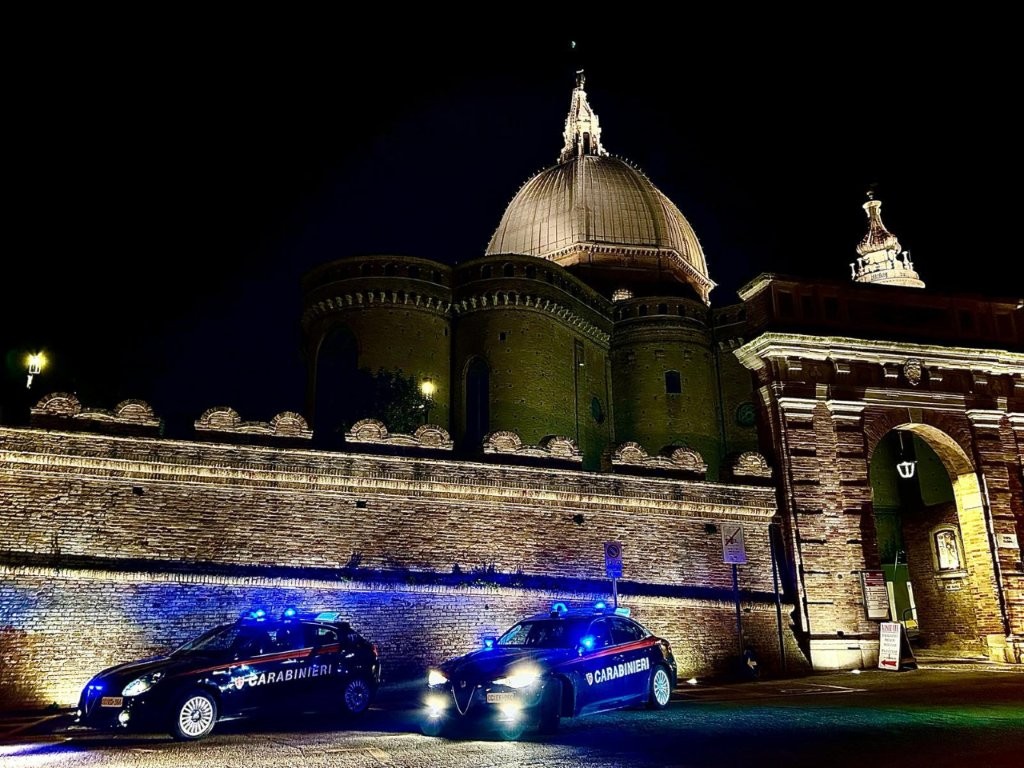 Vetture dei Carabinieri di notte davanti alla basilica di Loreto nella fotografia della fonte